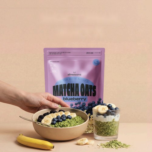 Bowl of matcha oats with blueberries and the Allreasons Matcha Oats pouch